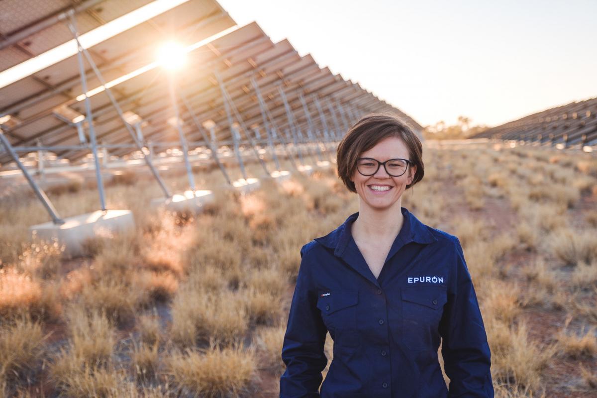 Woman standing in a field of solar panels