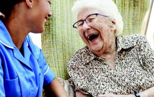 Carer and elderly woman have a laugh together
